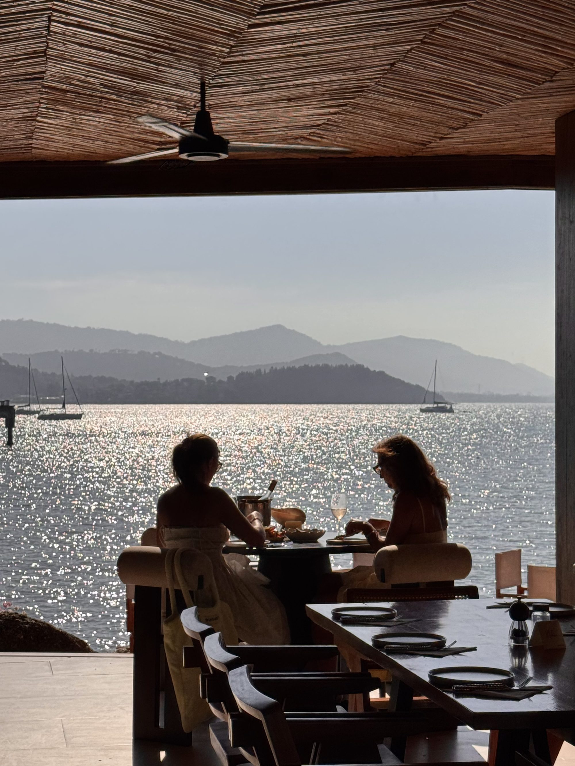 Guests at Nahm sharing a sunlit lunch on the water, Bangrak, Koh Samui