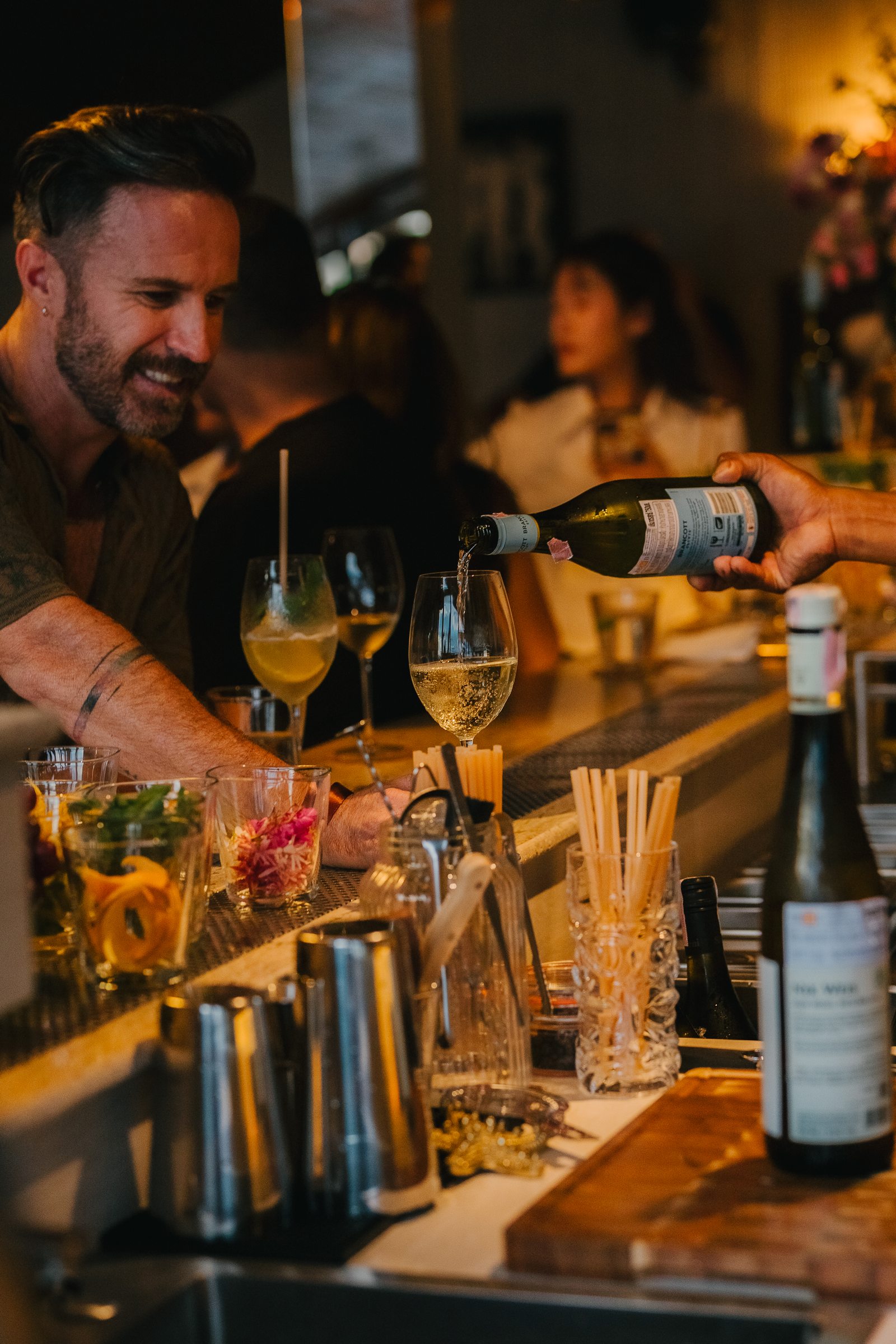 Bartender pouring wine for a guest at Soirée, Bangrak